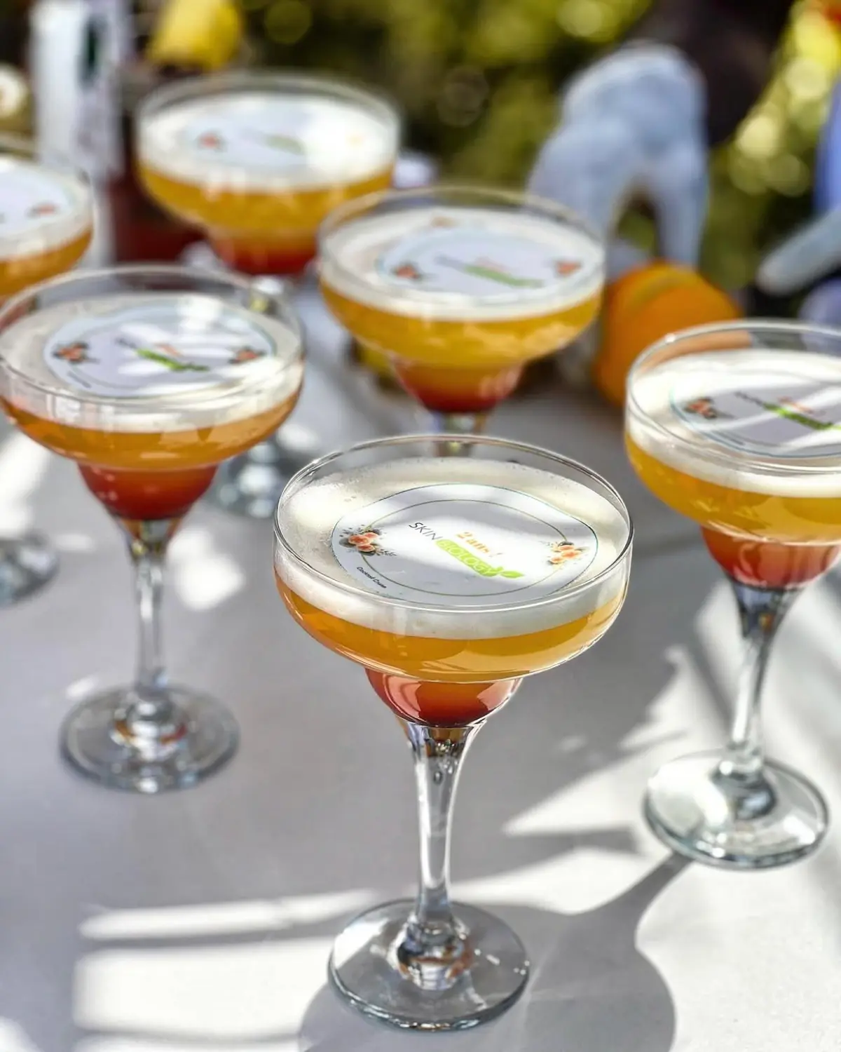 Coupes de cocktails coiffées de disques imprimés au logo de la marque SkinBiology