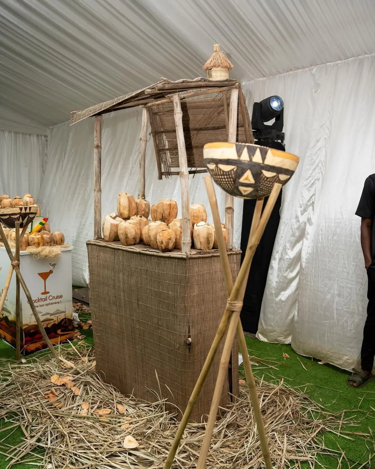 Stand traditionnel en paille tressée garni de noix de coco fraîches, torches en calebasse