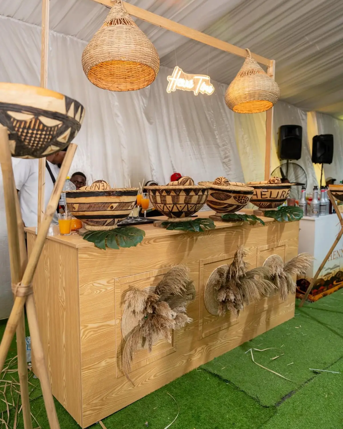 Bar de cérémonie du henné en bois clair, calebasses gravées et enseigne néon Henna Time