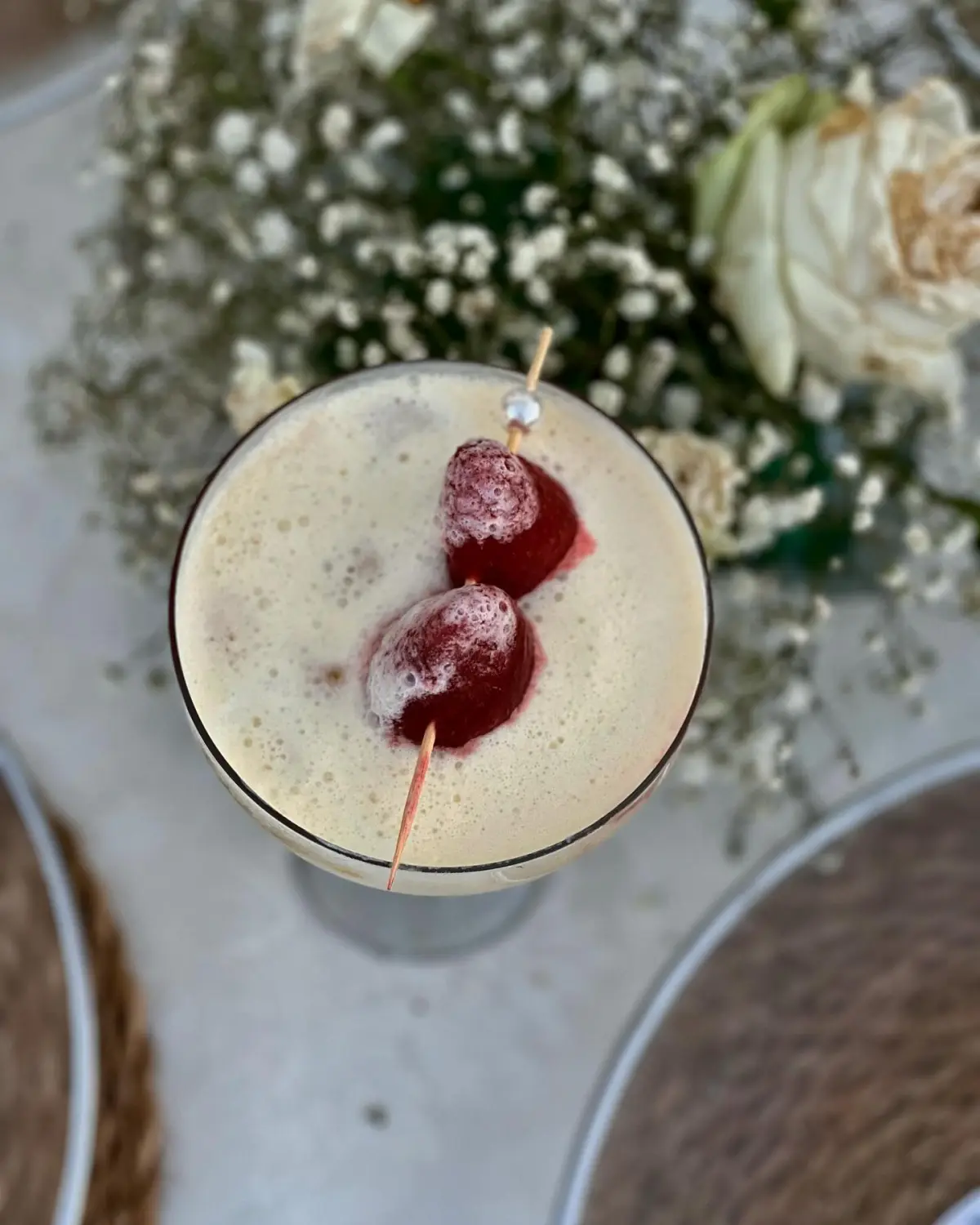 Pina colada douce vue de dessus, brochette de fraises perlée sur mousse crémeuse